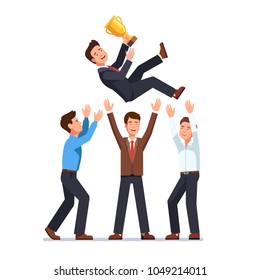 Business Man Team Tossing In The Air Winner Holding Golden Cup Trophy First Prize. Group Of Business People Celebrating Victory Achievement Throwing Colleague Up In The Air. Flat Vector Illustration