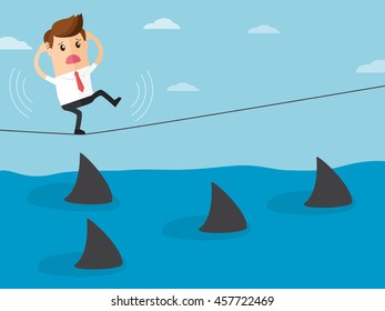 business man trying to walk on rope over a sea of sharks
