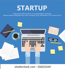 Business mans desk in office with typing hands and blue background and Startup sing