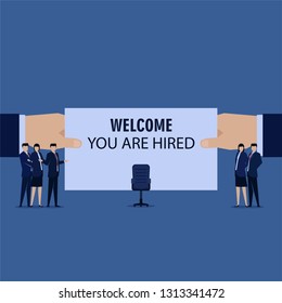 Business team welcoming new employee with chair on the middle.