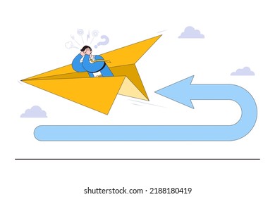 Business turning point, financial trend change, and break event concepts. Frustrated businessman investor fly using paper airplane at his reverse direction pathway with direction arrow backward.
