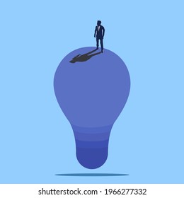 Business vision, creativity, and new ideas vector illustration concept. A man standing on a lightbulb thinking about an idea for solving a problem. Symbol of brainstorming, future, planning.