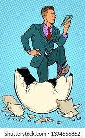 The businessman was born from an egg. Reads news in the smartphone. Pop art retro vector illustration kitsch vintage