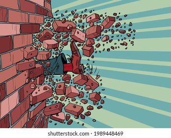 Businessman breaks through a brick wall. The will to overcome obstacles