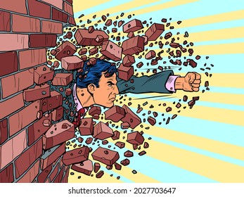 Businessman breaks through a brick wall. The will to overcome obstacles