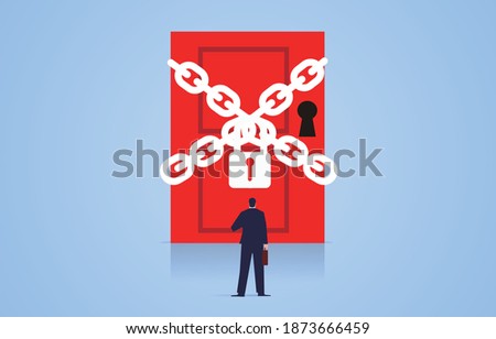 Businessman facing a door bound by chains