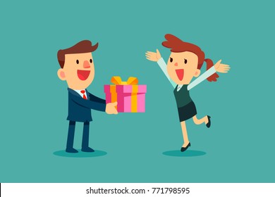 Businessman giving a holiday gift box to businesswoman. Office holiday celebration.