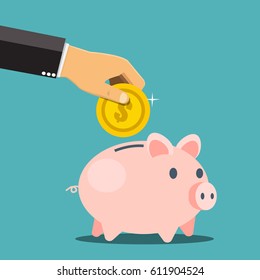 Businessman hand putting a coin into a piggy bank. Saving and investing money concept. 