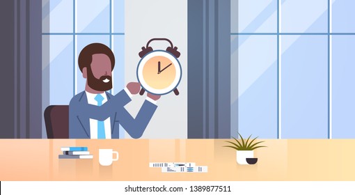 businessman holding alarm antique clock african american business man sitting workplace desk deadline time management concept modern office interior male character portrait flat