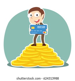 businessman holding credit card on pile of coins