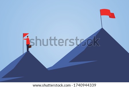 Businessman holding a flag standing on the top of the mountain, looking to another higher mountain, business goals and challenges