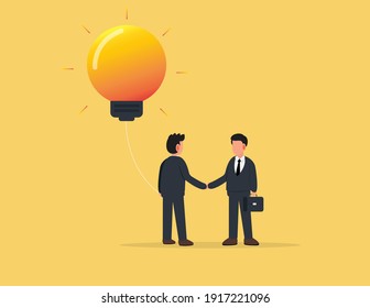 Businessman holding a huge light bulb and shaking hands with a businessman with briefcase.Startup and search of investments concept. Business investing to innovational idea.