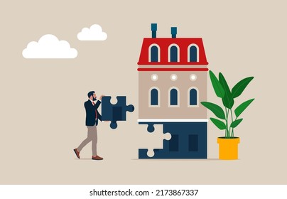 Businessman holding jigsaw piece to finish a house, complete puzzle parts of house, real estate investment.