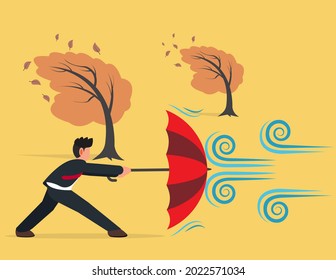 Businessman holding umbrella in protection for strong wind. survive crisis situation concept