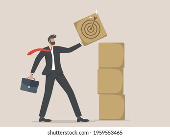 Businessman holding wooden cube with target