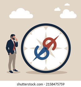 Businessman investor looking at compass with dollar sign direction. Economic direction or investment trend, financial indicator, inflation or interest rate direction, recession or growth concept.