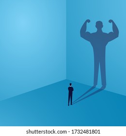 Businessman looking at his own strong personality shadow on wall, inner power concept