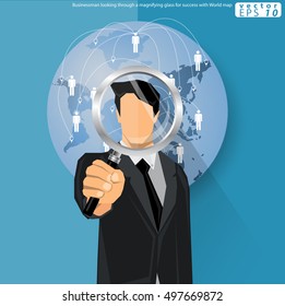 Businessman looking through a magnifying glass for success with World map
