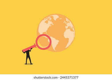 Businessman with a magnifying glass search opportunity on Earth. concept of global business research and development