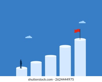 Businessman on bar chart looking at goal flag