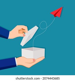 A businessman opens a box with a red paper plane. Different concepts for success
