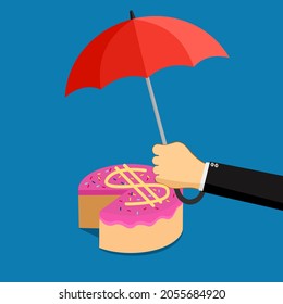  A businessman opens an umbrella to protect the money cake. Profit share protection concept