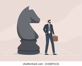 Businessman playing chess with big figures