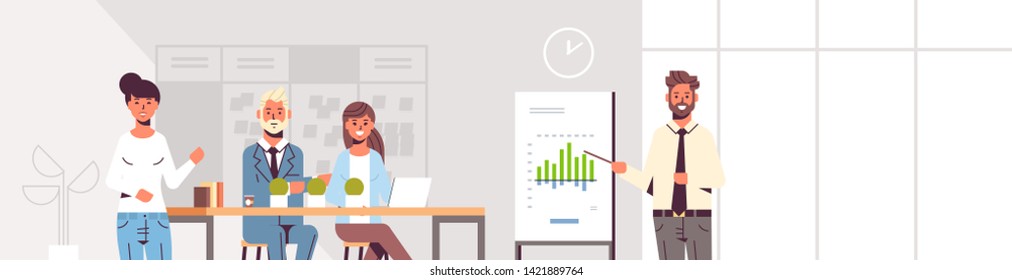 businessman presenting financial graph on flip chart to businesspeople team at conference meeting training presentation concept modern co-working space office interior portrait horizontal