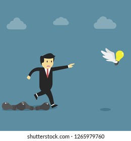 Businessman running try catch the flying idea while dead lamp on the floor.