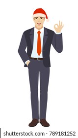 Businessman in Santa hat with hand in pocket showing a okay hand sign. Full length portrait of businessman in a flat style. Vector illustration.