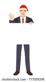 Businessman in Santa hat holding white blank poster and showing a okay hand sign. Full length portrait of businessman in a flat style. Vector illustration.