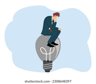 businessman sitting at a burnt out light bulb. concept has no idea. concept thinking idea