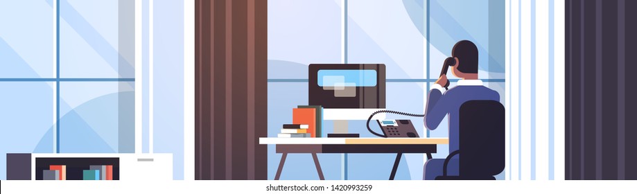 Businessman Sitting At Workplace Desk Rear View Business Man Using Computer While Talking On Landline Phone Working Process Concept Creative Office Interior Flat Horizontal Portrait