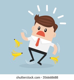 Businessman slipping on a banana peel.