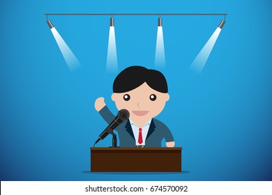 businessman speaking with microphone behind a table, speech and business concept