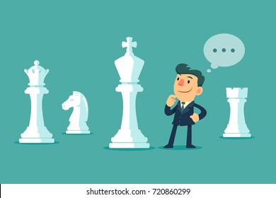 Businessman standing among big chess pieces planning a strategy. Business plan and strategy concept.