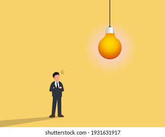 Empresario parado debajo de la bombilla. Buscando el concepto de creatividad