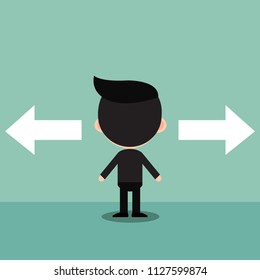 Businessman standing in front of two arrows.