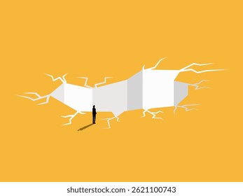 Businessman standing solving the problem of the earth cracking into a hole