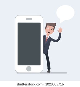 Businessman talking beside big smart phone with blank screen. Business communication concept. Vector illustration in a flat style