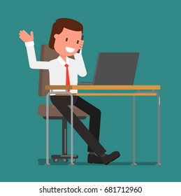 Businessman talking on the phone while sitting at the computer