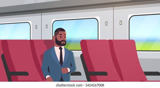 businessman traveling by train.  African American passenger man in suit sitting on comfortable chair during business trip.  Long distance public transport concept.  Horizontal portrait.