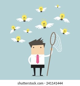 Businessman trying to catch a light bulb idea