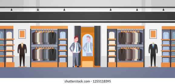 businessman trying on new business suit elegant man looking at mirror fashion shop male clothes market modern shopping mall interior flat horizontal