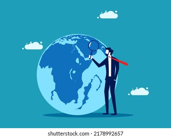 businessman uses a magnifying glass to look at the globe. business concept