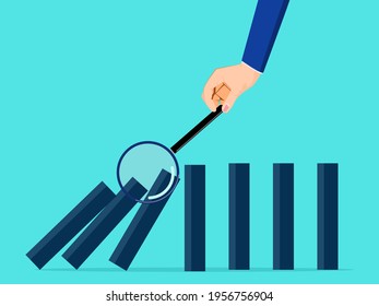 A businessman uses a magnifying glass to watch the domino fall. Risk analysis concept.