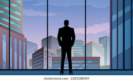 Businessman watching over the city from the window of his office.