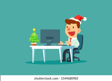 Businessman wearing santa claus hat while working in office with small christmas tree on his desk. Christmas celebration. Business concept.