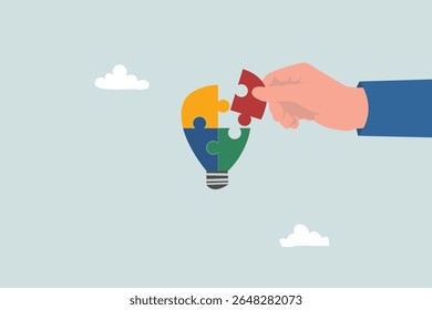 Businessman's hands arranging colorful light bulb puzzle pieces
