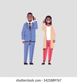 businesspeople couple using smartphones business man woman making calls talking on cellphone communication concept african american colleagues standing together flat full length